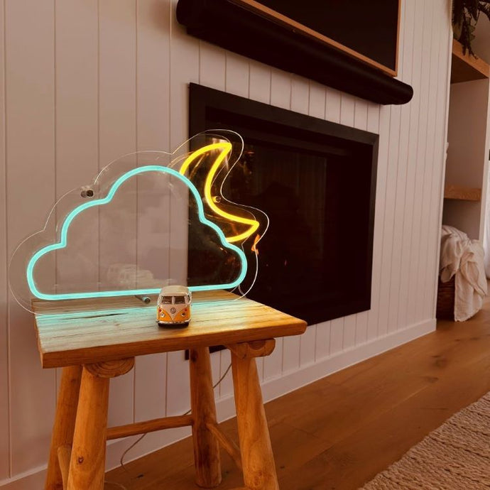 neon-sign-light-blue-cloud-yellow-moon-standing-on-a-table-infront-of-a-fireplace-and-vj-wall